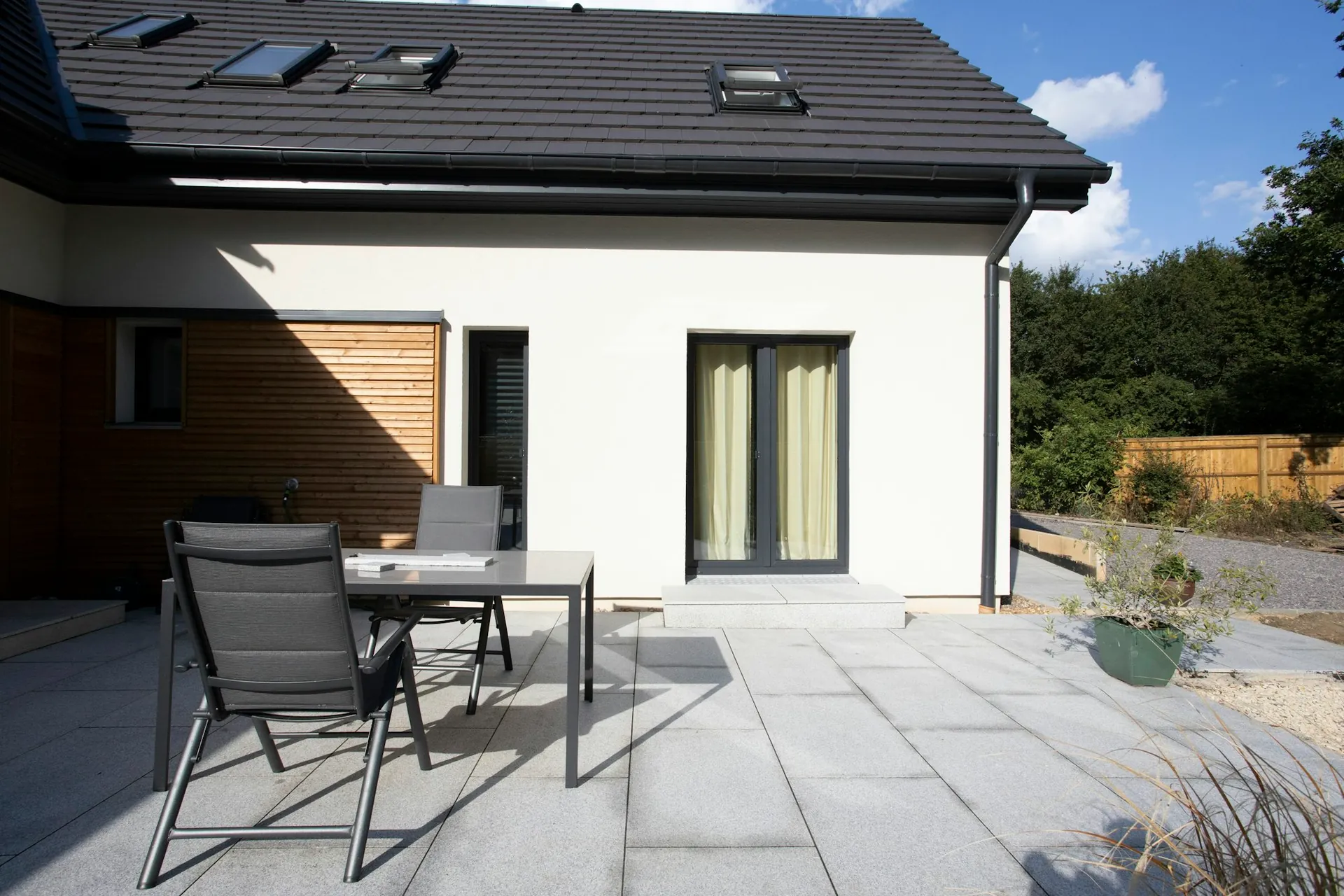 Fliseterrasse ved et hvidt hus