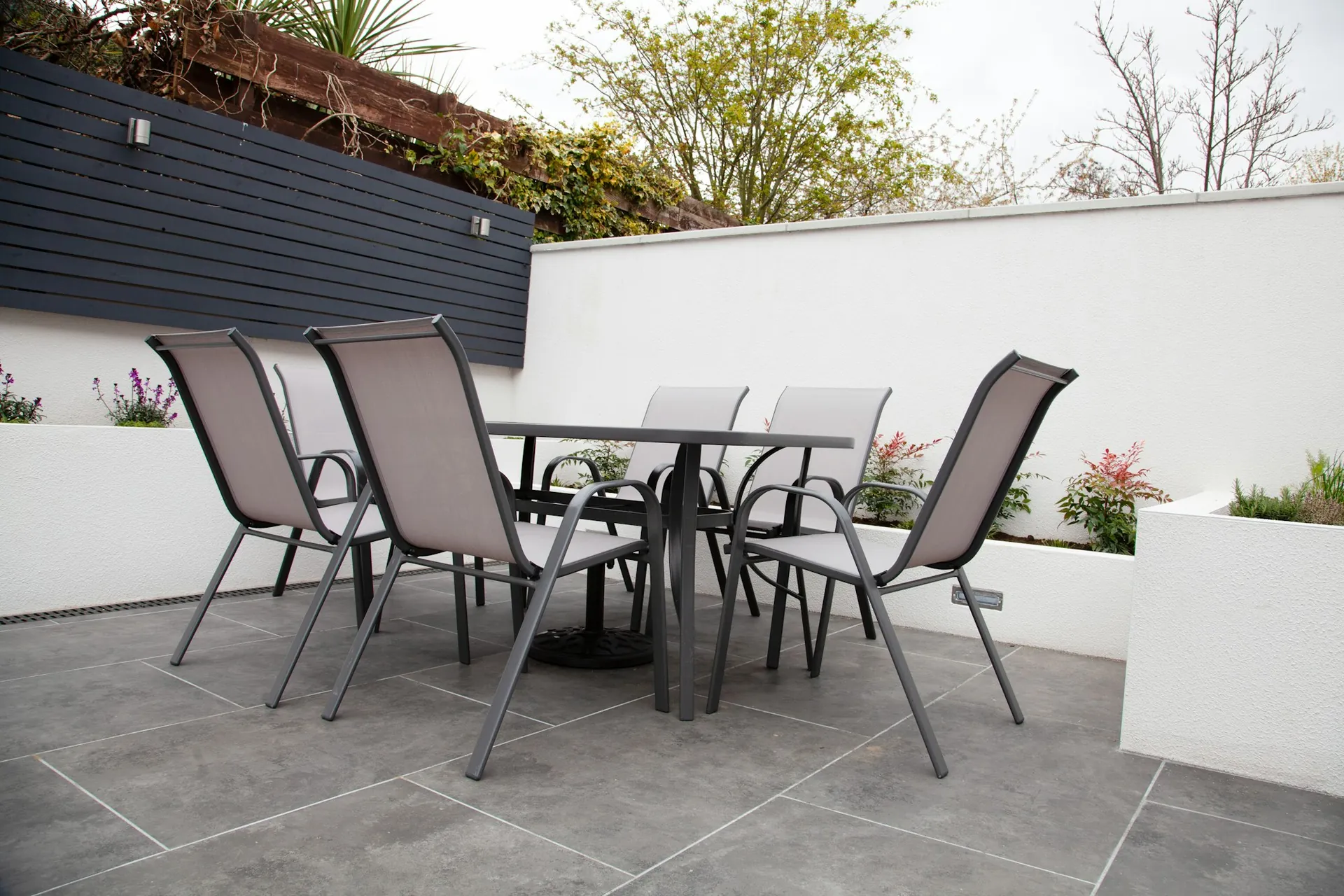 Terrasse med store fliser og spisebord